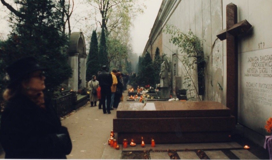 A woman examines a grave in Warsaw. What might she be thinking?